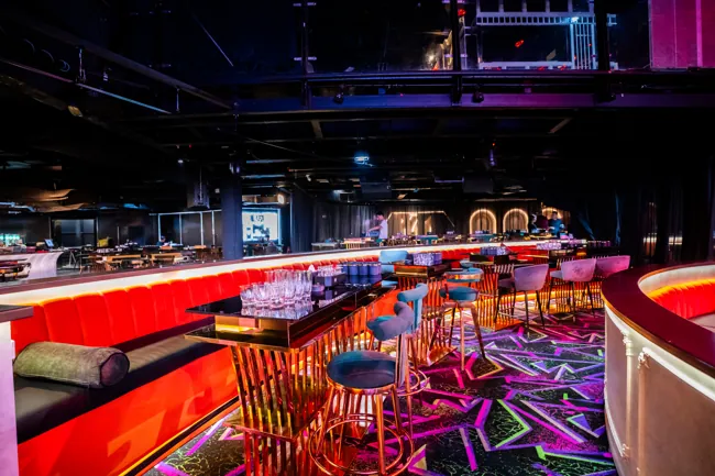 Balcony view across curved red sofas and the club stage at Millennium Club KL, Bukit Bintang