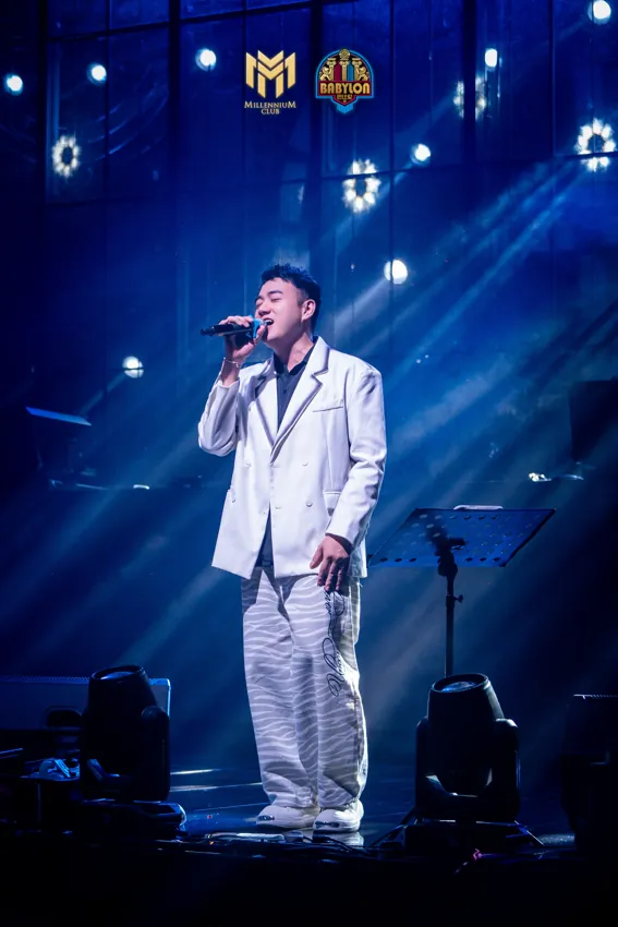 Male singer in a white suit under blue light at Millennium Club KL, Bukit Bintang