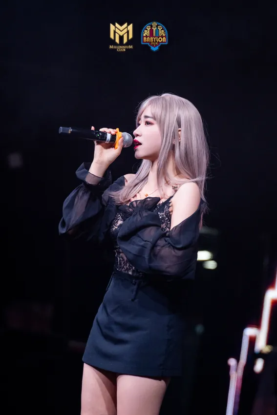 Female vocalist in black holding a microphone at Millennium Club KL, Bukit Bintang